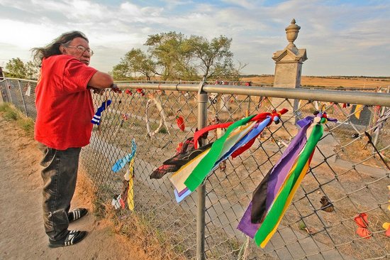 native american man and Lakota Sioux tribal spokesman Milo Yellowhair at the Wounded Knee on fence tied with colored ribbons