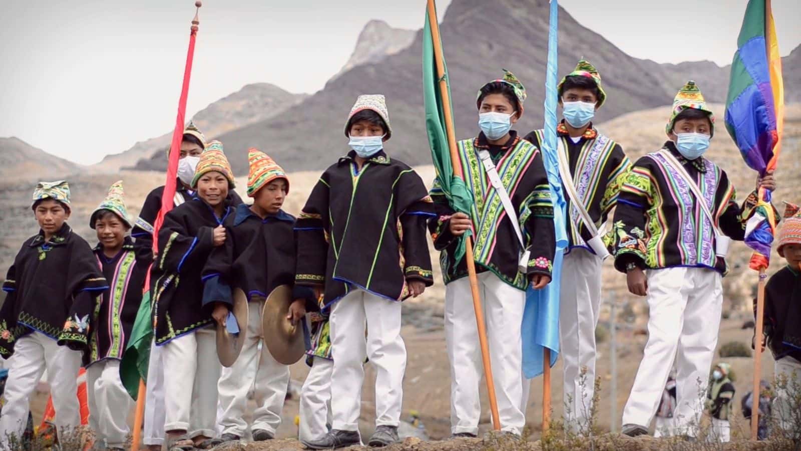 Schoolchildren of the Kallawaya Nation of northern Bolivia marched in their traditional dress and performed their music with traditional instruments in the procession that begins the snow festival in Ayllu Amarete. The festival is a reinforcement and a reminder of the importance of their ancestral memory. (Image from Cosmology & Pandemic: Legacy of the Andes / The Esperanza Project)