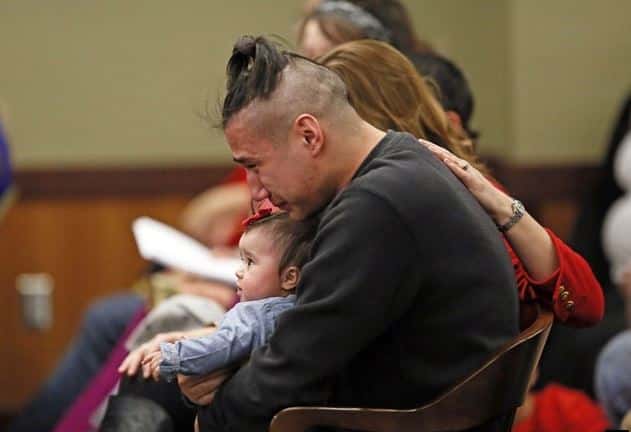 Savanna LaFontaine-Greywind's boyfriend Ashton Matheny holds their daughter, Haisley Jo, as victim impact statements are read during the sentencing of Brooke Crews at the Class County District Court of February 2, 2018. David Samson / The Forum