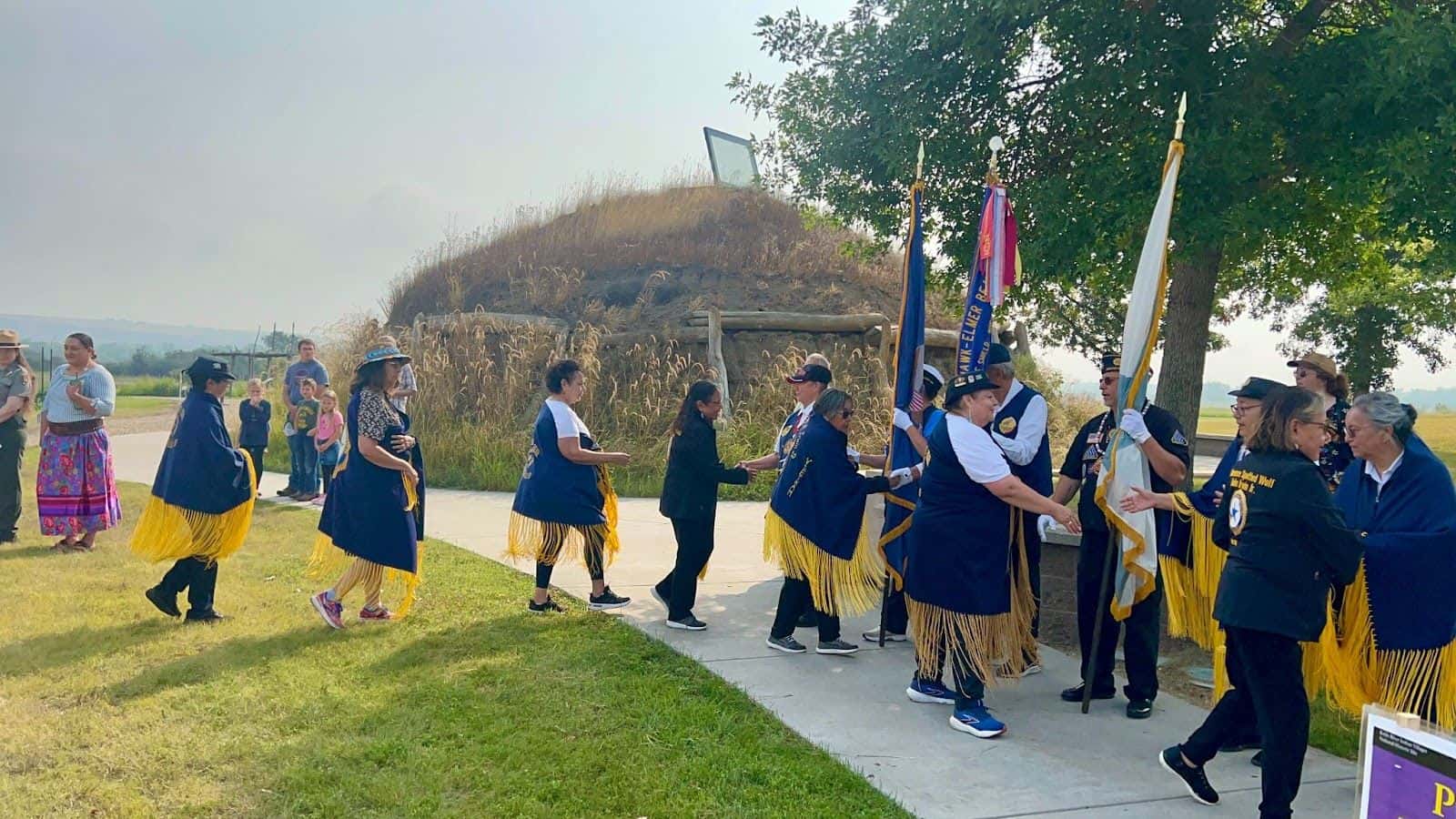 American Legion Auxiliary unit members from tthe Fort Berthold Reservation shake hands near an earth lodge at the Knife River Historic Site on Saturday, Aug. 17. (Photo Credit/ Jodi Rave Spotted Bear)