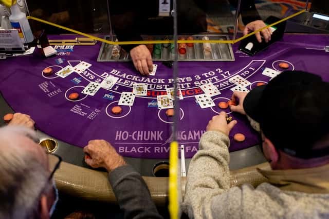 Players at Ho-Chunk Gaming Black River Falls in Wisconsin play at the blackjack table on Feb. 9, 2022. Tribes are now weighing how to diversify their economies beyond casinos. “When we see anything less profitable, there’s a thought of, ‘Is it worth it?’” said Ho-Chunk Nation President Marlon WhiteEagle of his tribe’s investment in casinos. (Photo by Ilana Bar-av for Wisconsin Watch)