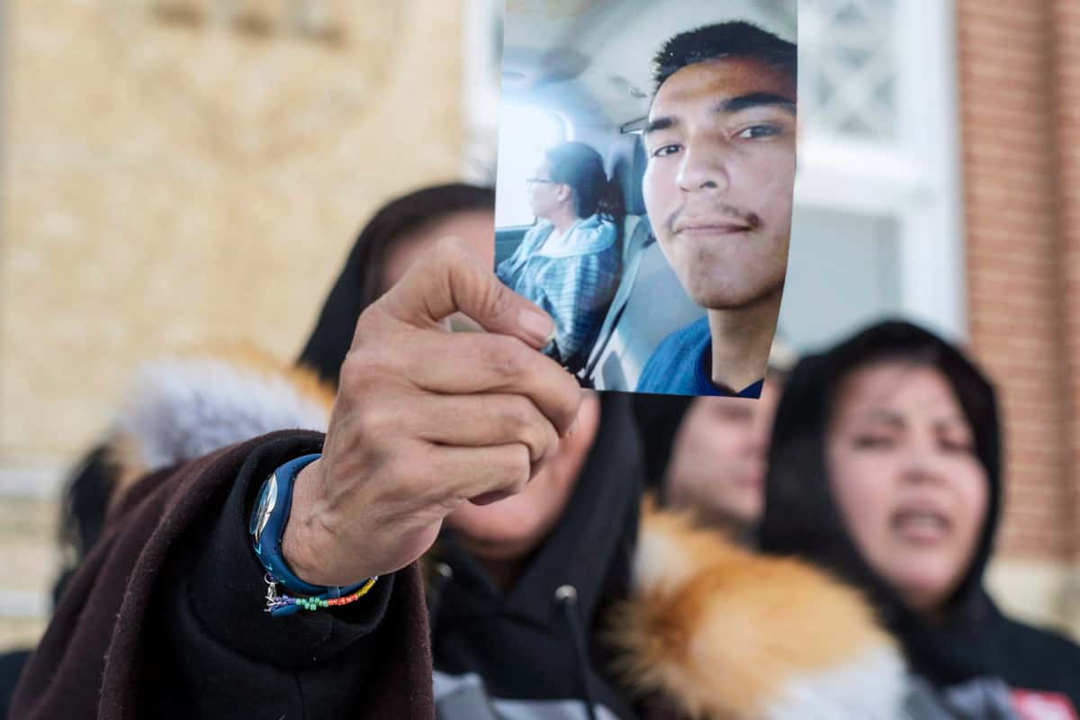 In this Feb. 5, 2018, photo, Debbie Baptiste, the mother of Colten Boushie, holds up a picture of her son as she leaves the Court of Queen's Bench during a lunch recess on the fifth day of the trial of Gerald Stanley, the farmer accused of killing the 22-year-old Indigenous man, in Battleford, Saskatchewan. (Liam Richards/The Canadian Press via AP)