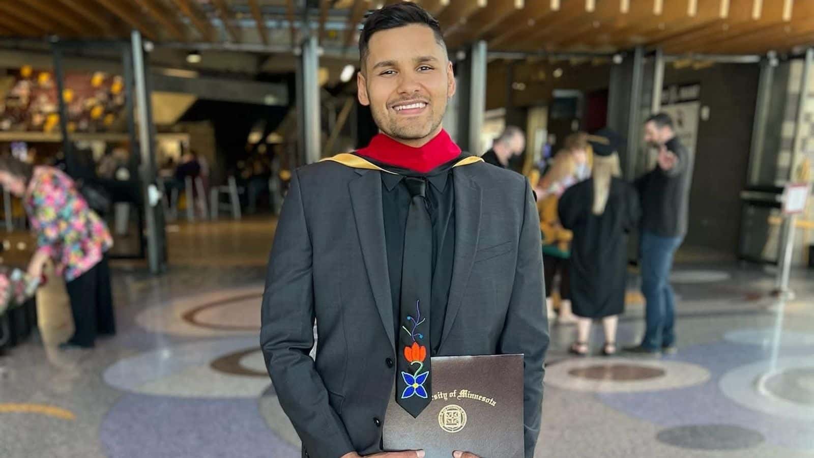 Curtis Rogers holds his master’s degree in tribal administration and governance outside AMSOIL Arena in Duluth, Minnesota, May 2022. (Photographer: Rachel Rogers)