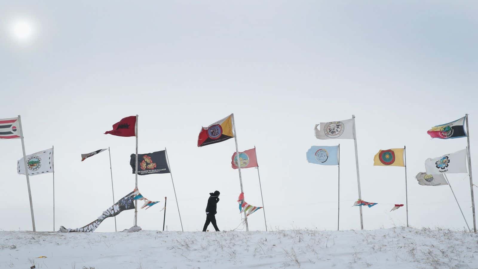  CANNON BALL, ND – DECEMBER 06: An activist fights the wind as while walking along Flag Road in Oceti Sakowin Camp as blizzard conditions grip the area around the Standing Rock Sioux Reservation on December 6, 2016 outside Cannon Ball, North Dakota. Native Americans and activists from around the country have been at the camp for several months trying to halt the construction of the Dakota Access Pipeline. The proposed 1,172-mile-long pipeline would transport oil from the North Dakota Bakken region through South Dakota, Iowa and into Illinois. (Photo by Scott Olson/Getty Images)