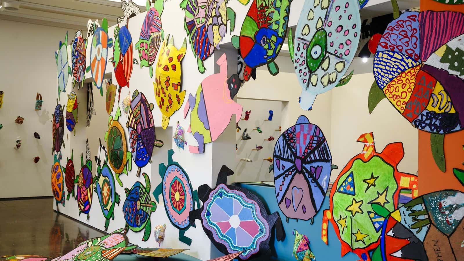 Vibrant student artworks in the shape of turtles cover the wall and floor of a gallery space in the Aspen Art Museum for the Youth Art Expo opening April 29. The museum retained some of the infrastructure from an Hervé Télémaque exhibition for the new show, which features more than 1,000 pieces by local youth.