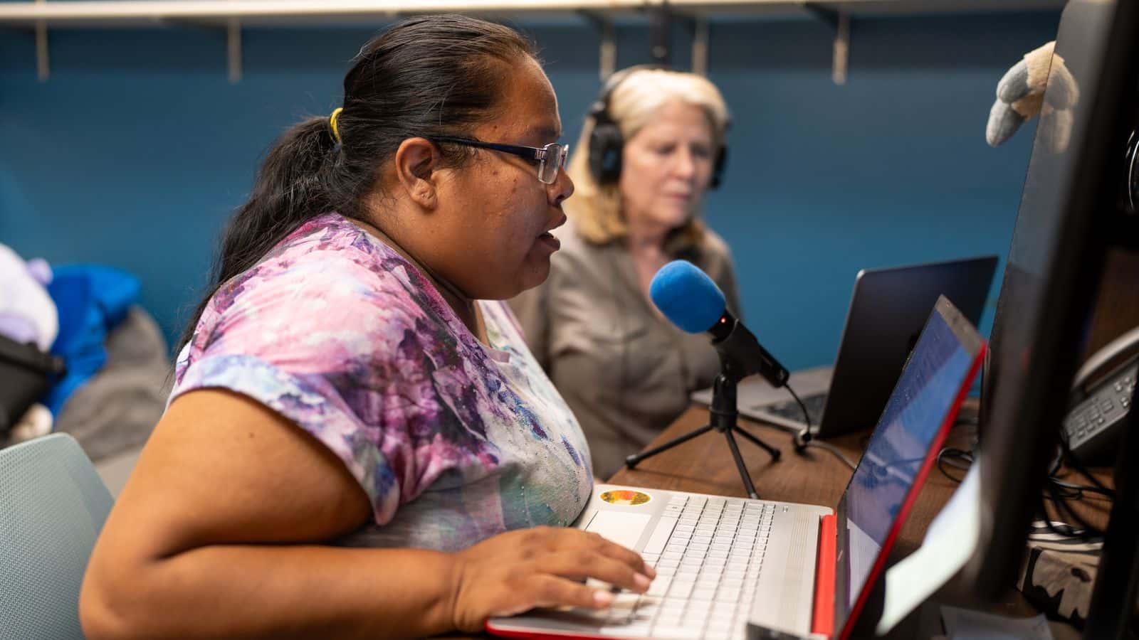 TR Mitchell records a voiceover for an audio story during an All Our Kin class. Mary Ann McNair, director of StoryCenter, a company that helps facilitate storytelling projects, helps Mitchell with the recording.