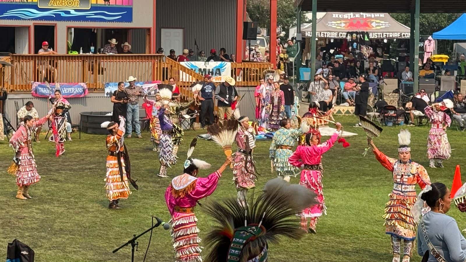 Dancers take part in a Jingle Dress dance August 9 at the Little Shell Celebration powwow at the Antelope Society Arbor in New Town, N.D. Some powwows are held in arbors like this one, while others take place in open fields with temporary arenas where spectators bring their own chairs. (Photo credit: Jodi Rave Spotted Bear)