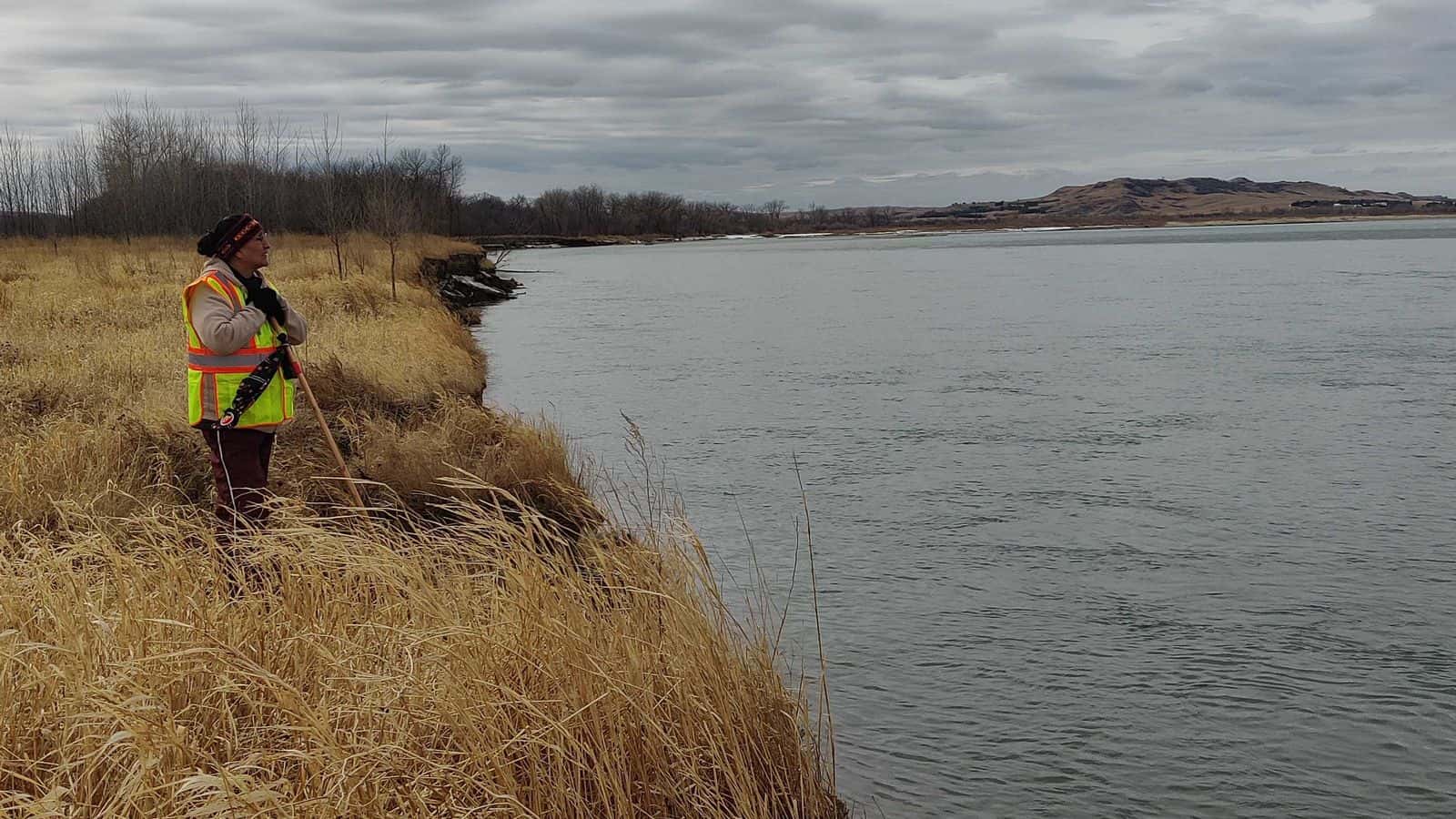 A searcher surveys the water from shore during the search for Renzo Bullhead on March 27.