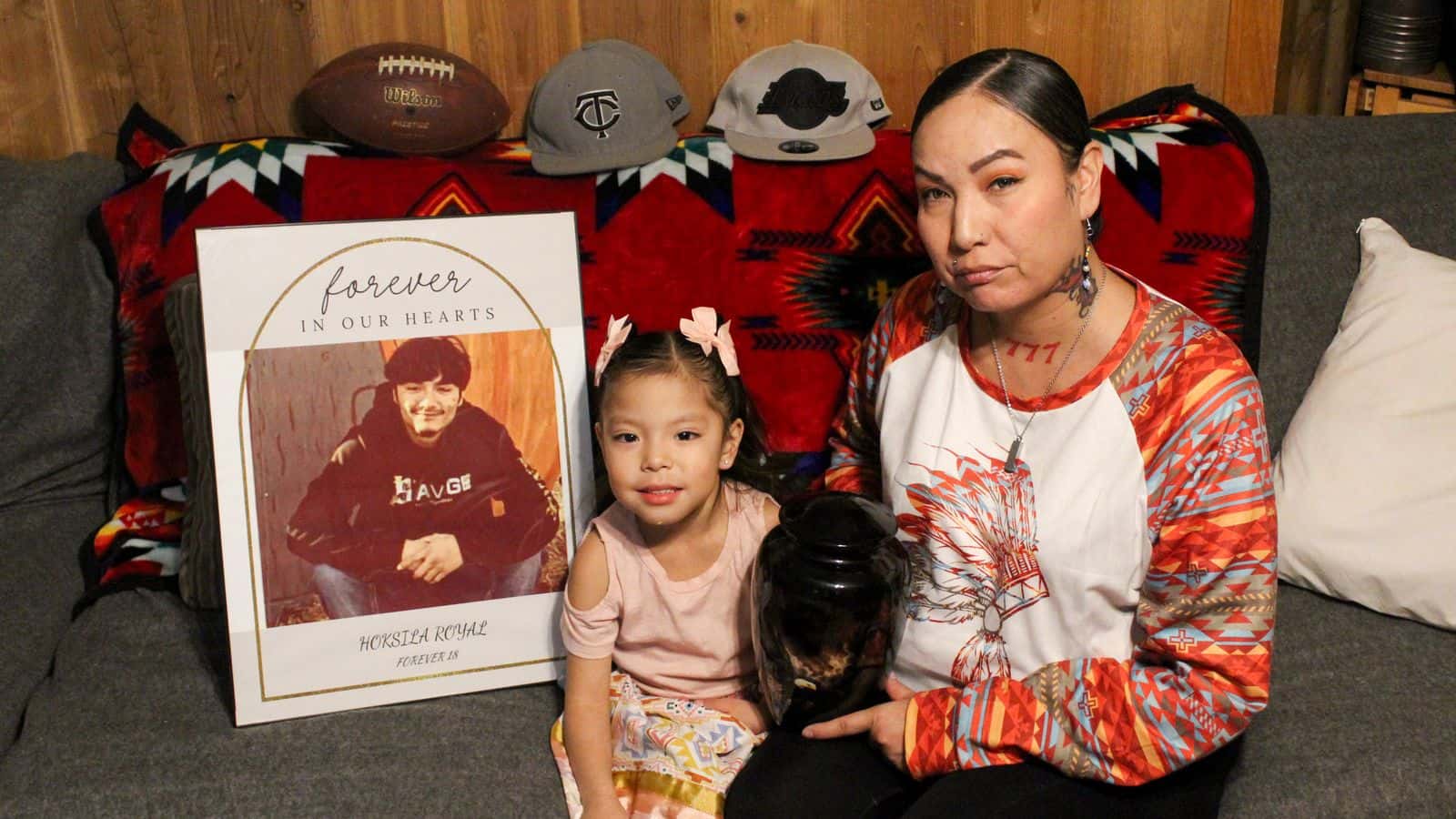 Brittney Rough Surface-Arnett sits on her couch with her granddaughter Arianna, holding an urn containing her son’s ashes, Mandan, North Dakota, Thursday, Jan. 22, 2026. (Photo credit: Marcus Taken Alive)