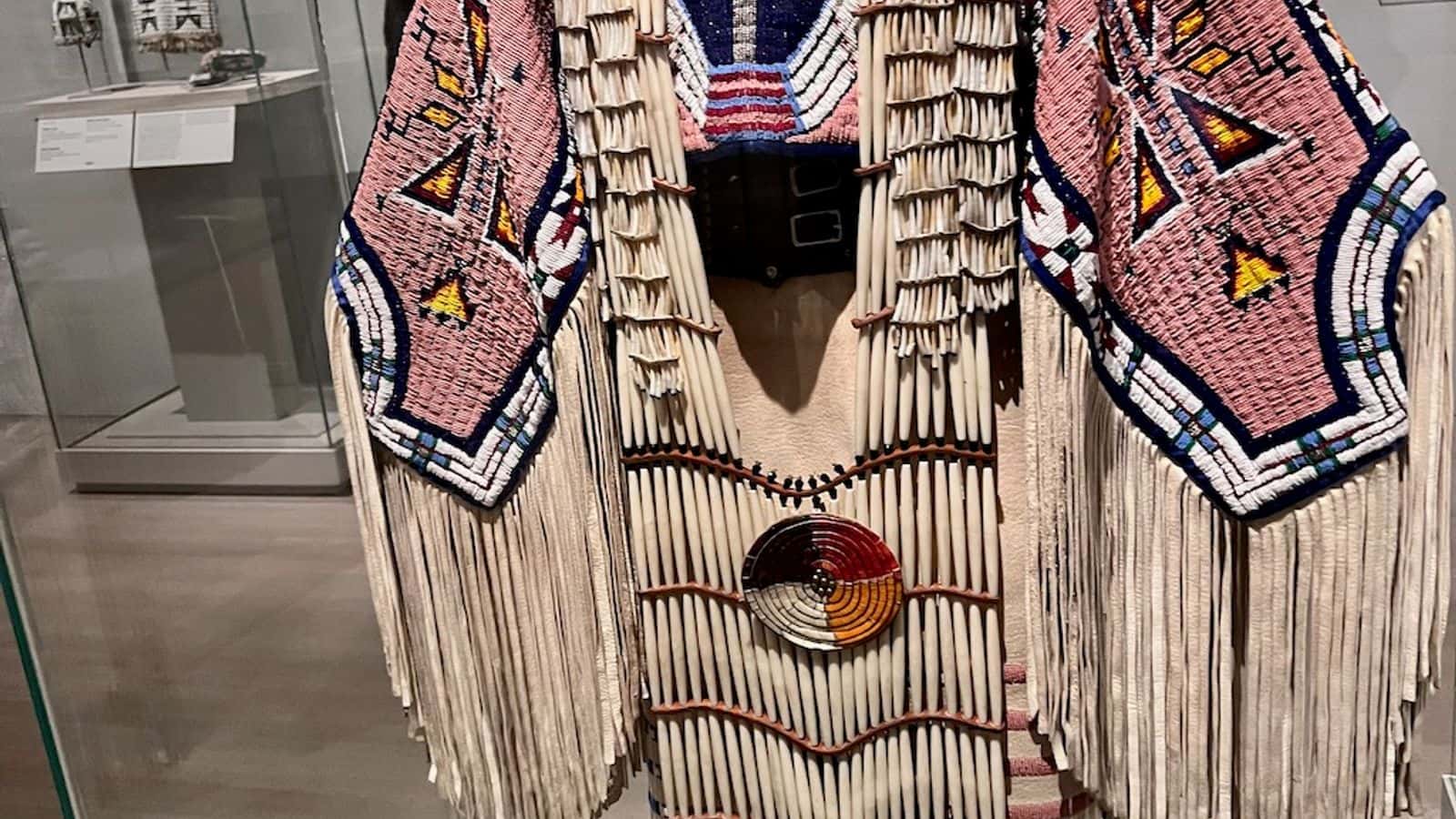 This Northern traditional woman's dress belongs to Jodi Archambault, Hunkpapa Lakota/Teton Sioux. It was designed in 2005 and created for powwow competitions. It features leather, glass beads, bone and dentalium shells. The dress was on exhibit, July 18, 2023, at The Met Museum in New York (Photo Credit: Jodi Rave Spotted Bear).