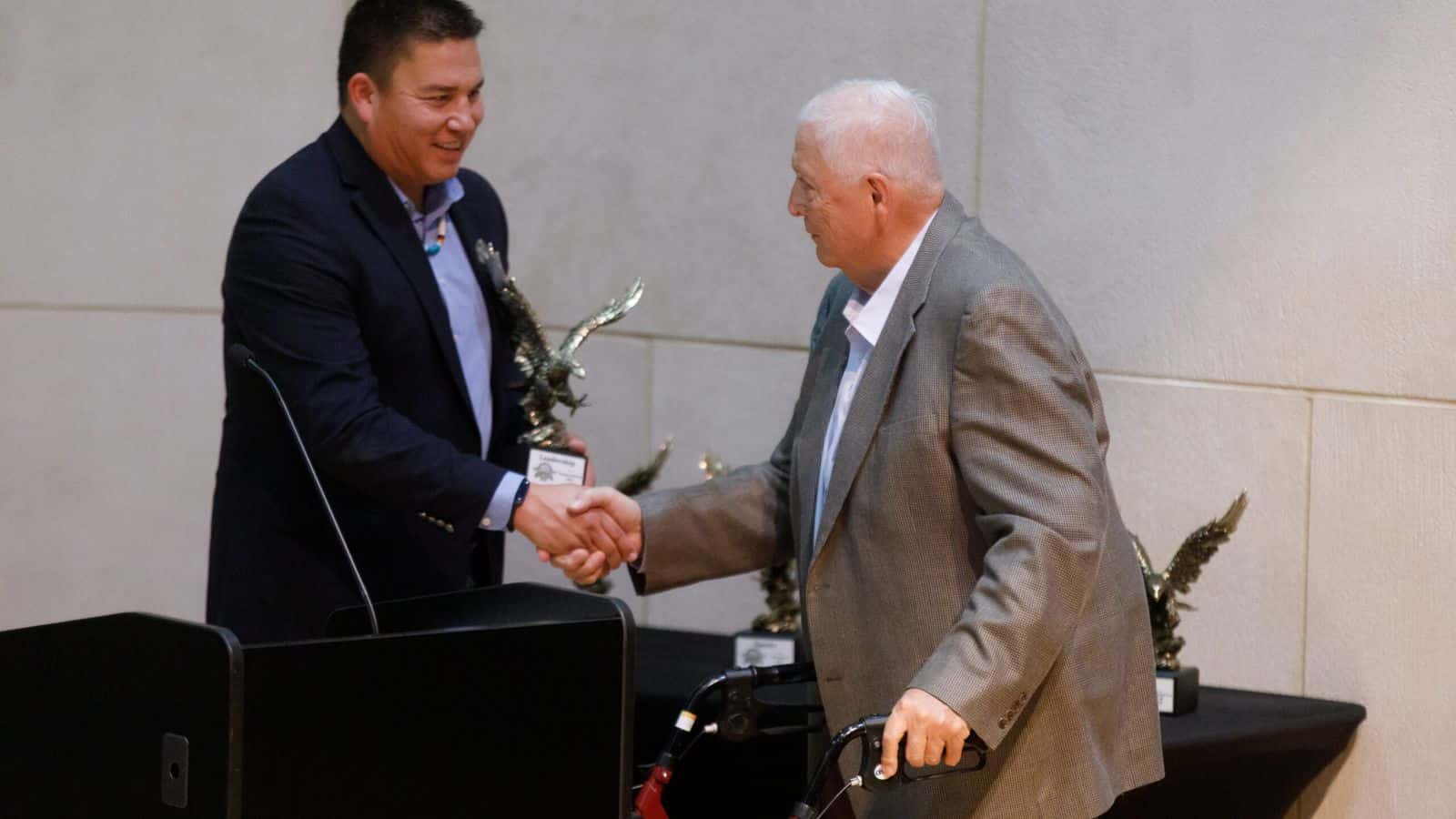  Thomas Fredericks, a retired tribal law attorney, receives a leadership award from Indian Affairs Commission Executive Director Brad Hawk during the North Dakota Native American Hall of Honor induction ceremony on Nov. 15, 2024. Fredericks is a member of the Mandan, Hidatsa and Arikara Nation. (Kyle Martin/For the North Dakota Monitor)