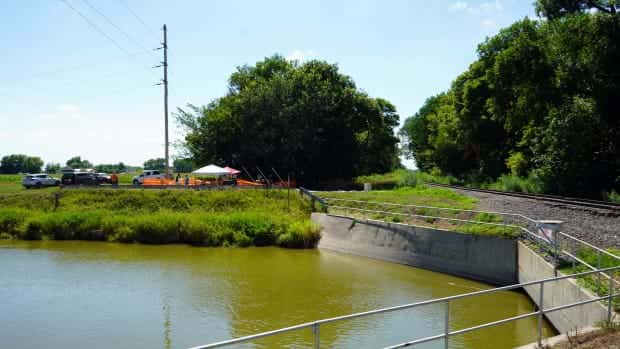 The dig site at the Genoa Boarding School can be seen on Wednesday, July 12, 2023 on the other side of a canal that was built following the school's closure in 1934. Railroad tracks also can be seen just to the north of the dig site. (Kevin Abourezk, ICT News)