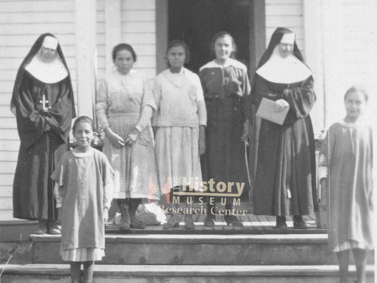 Children and Ursuline nuns stand in front of a church at St. Labre Indian School, a pre-K through 12th-grade school in Ashland, near the Northern Cheyenne Indian Reservation. (Photo courtesy The History Museum in Great Falls, Montana)