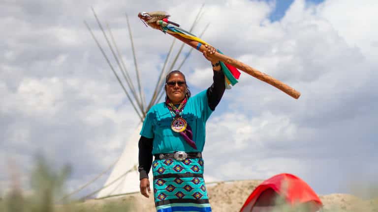 Dorece Sam Antonio holds her eagle staff on May 17, 2023 at Newe Momokonee Nokotun or Ox Sam Camp in Thacker Pass. Photo by Jarrette Werk (Underscore News / Report for America)