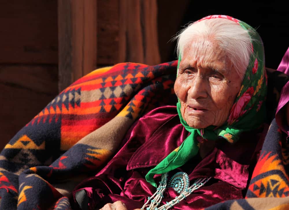 An,Elderly,Native,American,Woman,Sits,Among,Blankets.,She,Is