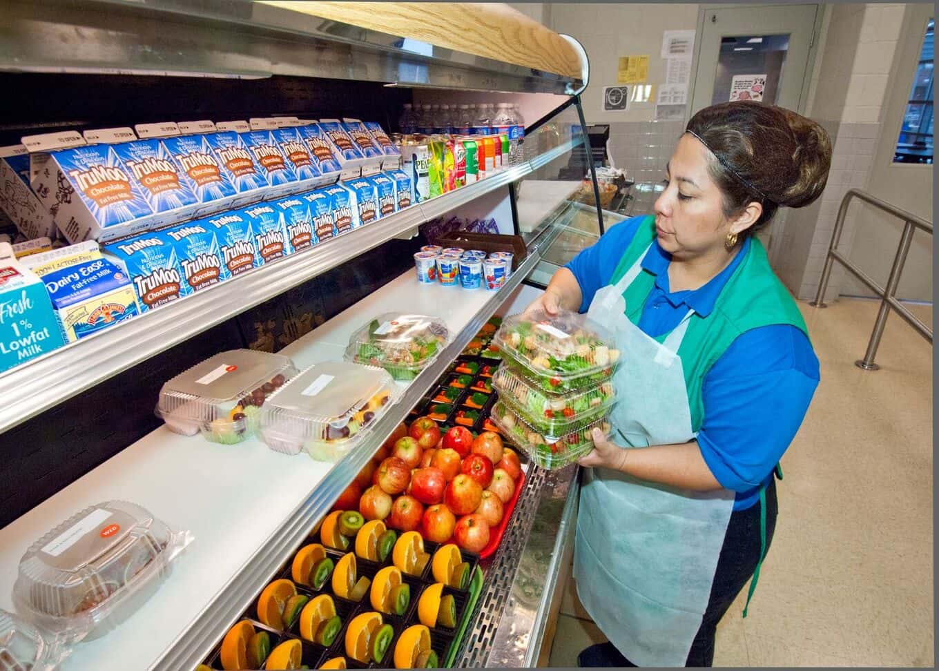 Magaly Valentin, Arlington Food Services, places fresh salads available to students through the National School Lunch Program at Washington-Lee High School in Arlington, Virginia, on Wednesday, October 19, 2011. The National School Lunch Program is a federally assisted meal program administered by the United States Department of Agriculture. (Photo by Bob Nichols, USDA)
