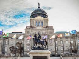 The Montana Capitol with each of the state's tribal flags. (Eliza Wiley/Montana Free Press)