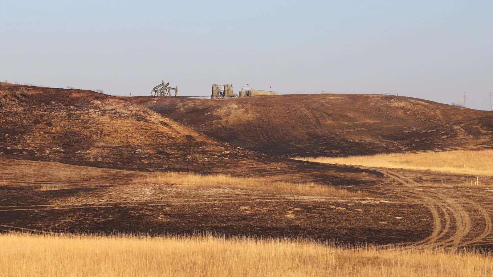 Oil wells continue to operate near scorched ground south of Watford City on Oct. 9, 2024. (Jacob Orledge/North Dakota Monitor)
