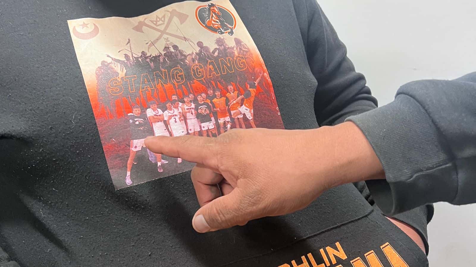 Delaine Blue Thunder, father, points to the local basketball team on Diedra Leaf’s Proud Mama hoodie on March 24, 2025. Her son, Renzo Bullhead is seen in the team photo. He graduated from McLaughlin High School in McLaughlin, South Dakota.