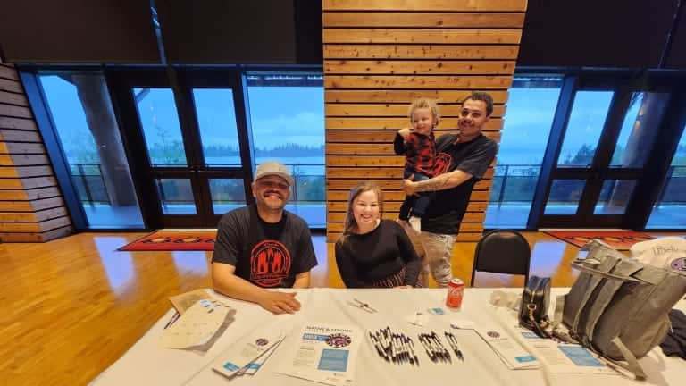 From left, Robert Coberly, Tulalip, tribal crisis counselor; Heaven Arbuckle, Tulalip, tribal crisis counselor lead; and Arbuckle's husband, Brandon Hachett, Tulalip, holding their son Roman. The group had an information table for the Native and Strong Lifeline at a recent Missing and Murdered Indigenous People event in Tulalip, Washington. (Photo courtesy of Native and Strong Lifeline)