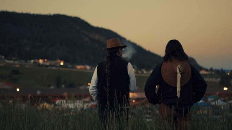 Julian Brave NoiseCat and his father Ed Archie NoiseCat look down at the Williams Lake Stampede from the top of “Indian Hill” on their roadtrip back to St. Joseph’s Mission, where Ed was born. (Credit: Emily Kassie/Sugarcane Film LLC)