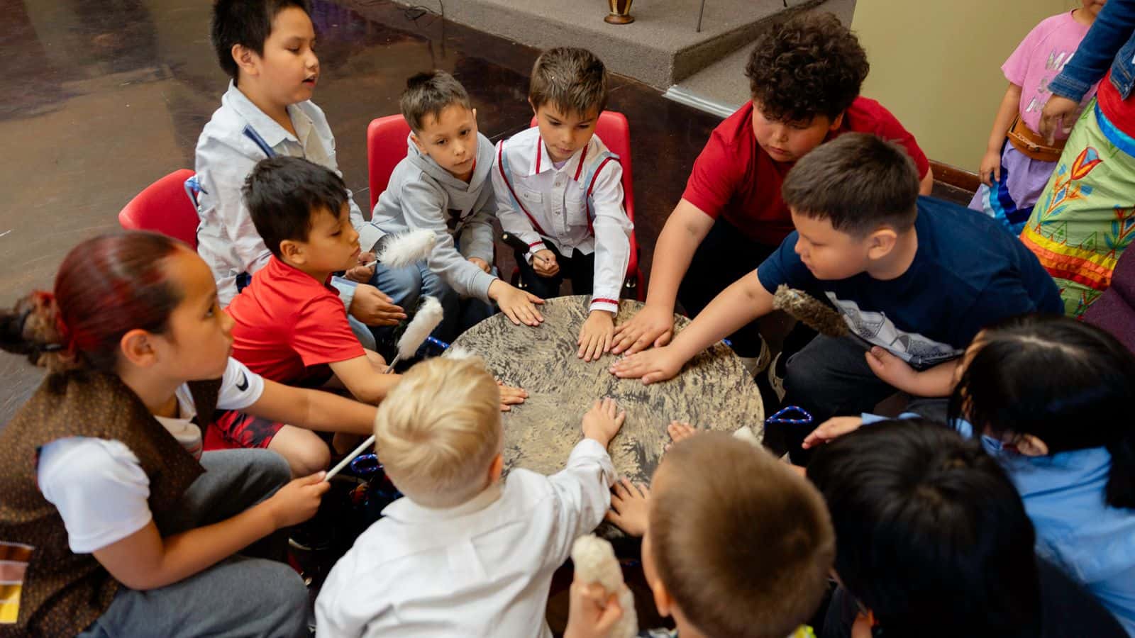 Students at the Oceti Sakowin Community Academy-- a culture-based school supported by grant funding and land from NDN Collective-- join around the drum for a prayer song in Rapid City, South Dakota. May 2024.