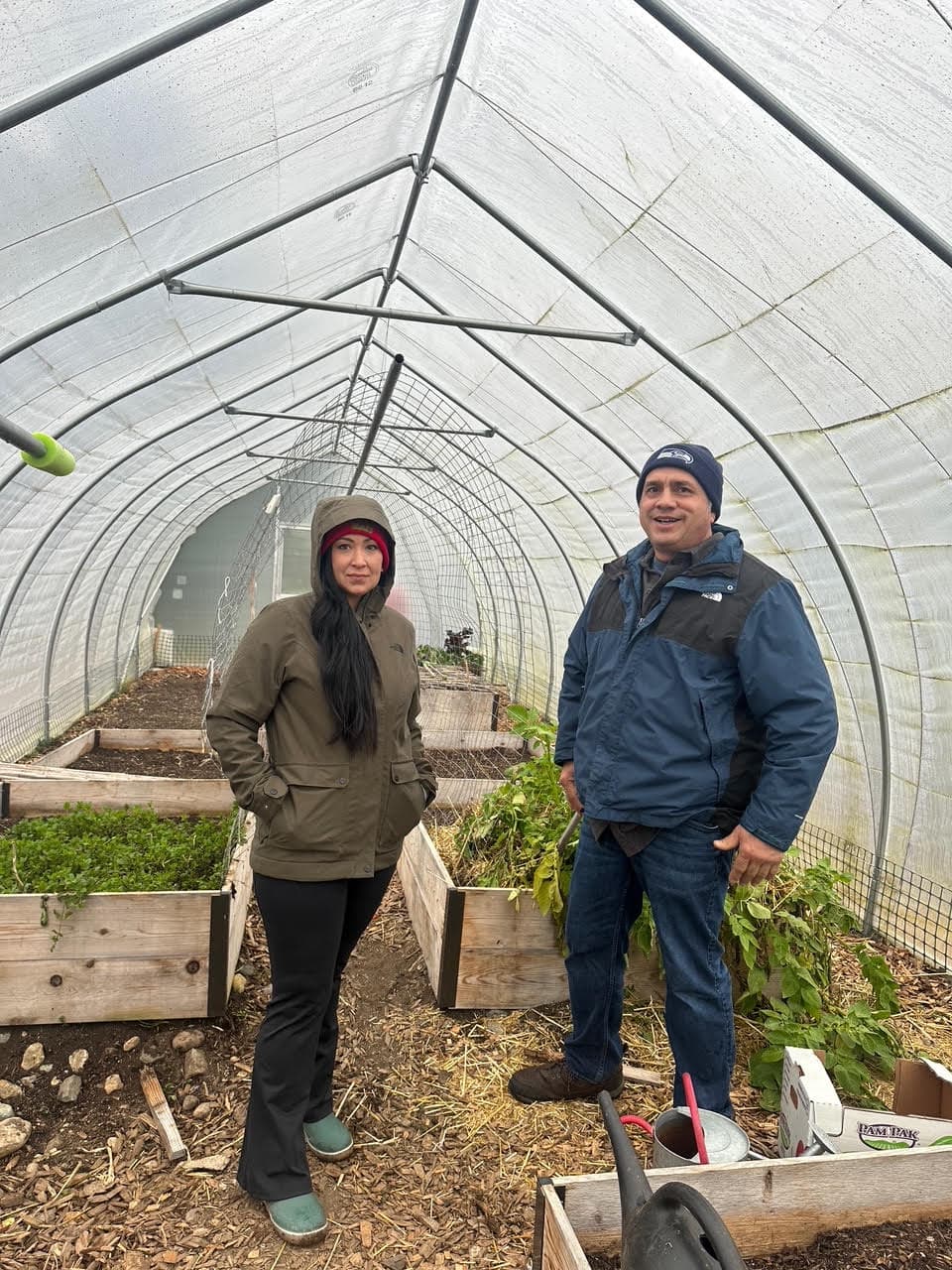 Beth Willup and Joe Quintasket stand in the Swinomish community garden greenhouse, January 2025.