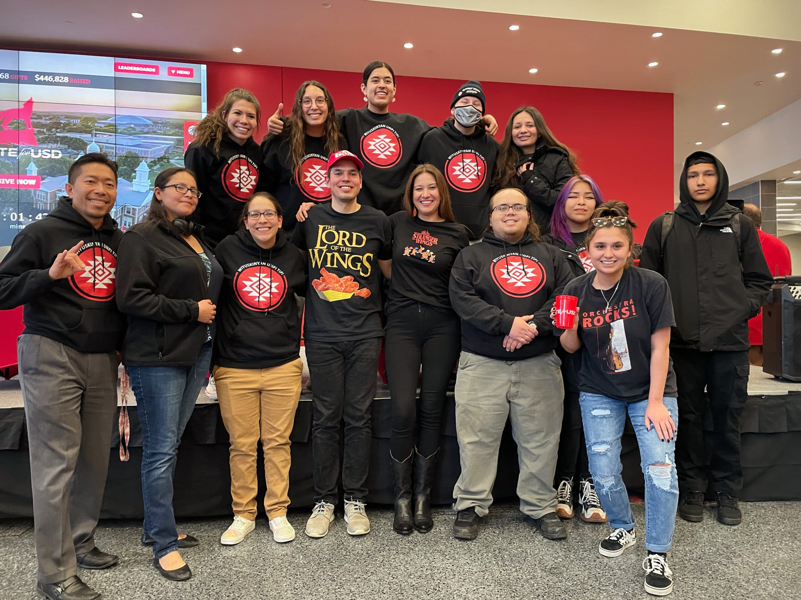 John Little and Megan Red Shirt-Shaw join Wiyuskinyan Unpi Tipi Living Learning Community students and staff at the Unite for USD fundraiser, March 1, 2023. The couple, in the center, entered a hot wing-eating challenge to raise money for the LLC programming.