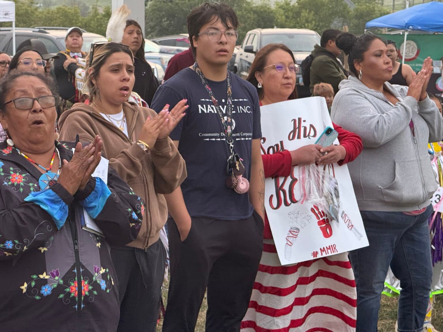 Alva Cottonwood-Gabe, leader of the Standing Rock Missing and Murdered Indigenous Relatives, joins family members of Renzo Bullhead during the Red Dress Special. Bullhead went missing in March. He was last seen crossing the train bridge into Bismarck from Mandan. His family is still searching for him. (Photo credit: Erin Hoover Barnett) 