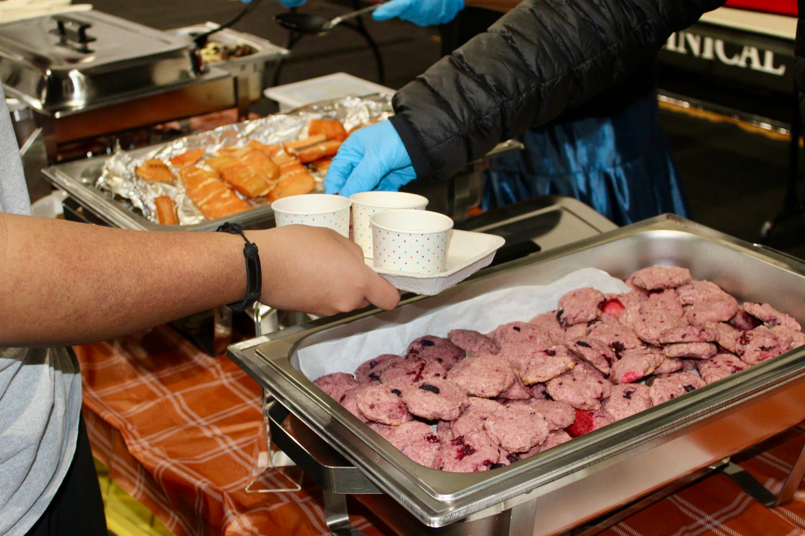UTTC students from Sisseton-Wahpeton Oyate serve wild berry blue cornmeal cookies, smoked salmon and soup at the “Taste the Earth” event, Bismarck, North Dakota, Tuesday, Nov. 25, 2025.