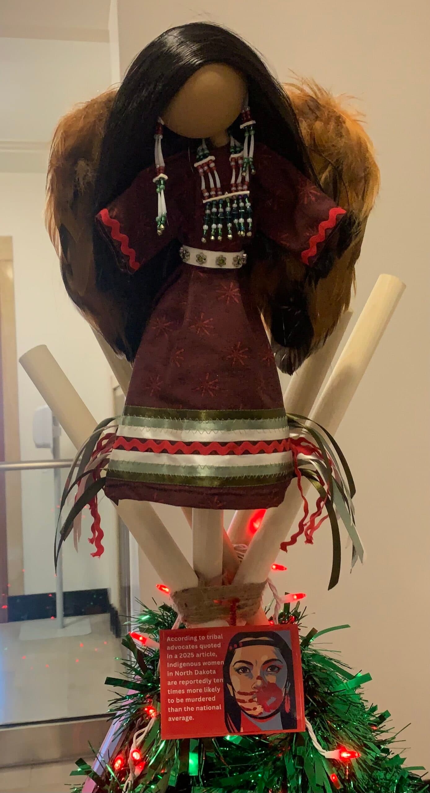 A Native angel wearing Christmas colored dentalium earrings and a ribbon skirt tops the MMIP Christmas tree, Bismarck, North Dakota, Monday, Dec. 15, 2025. (Buffalo’s Fire/Jolan Kruse)