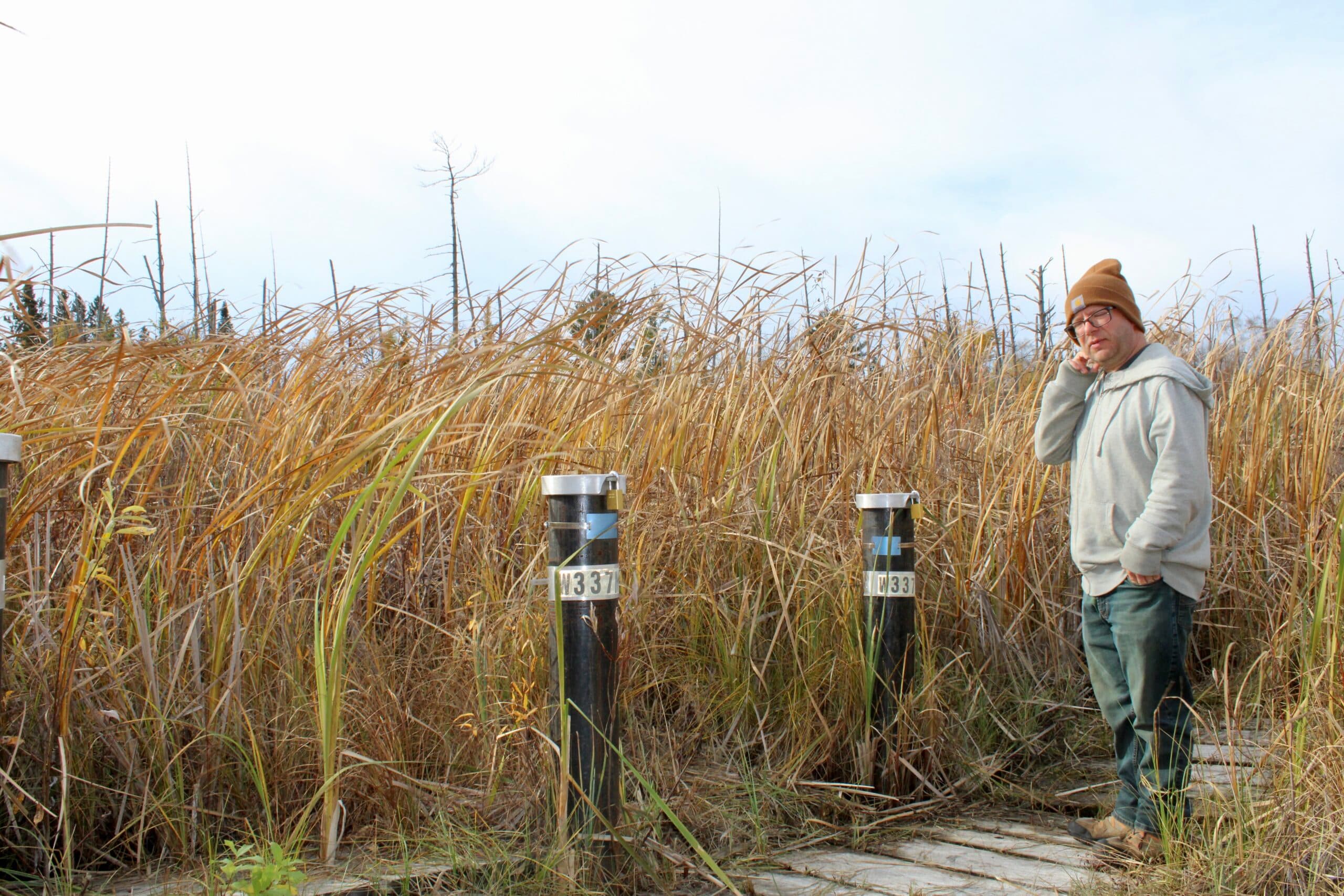 Eric Krumm, superfund coordinator for the Leech Lake Division of Resource Management, stands next to monitoring wells at Fox Creek Valley, Cass Lake, Minnesota.
