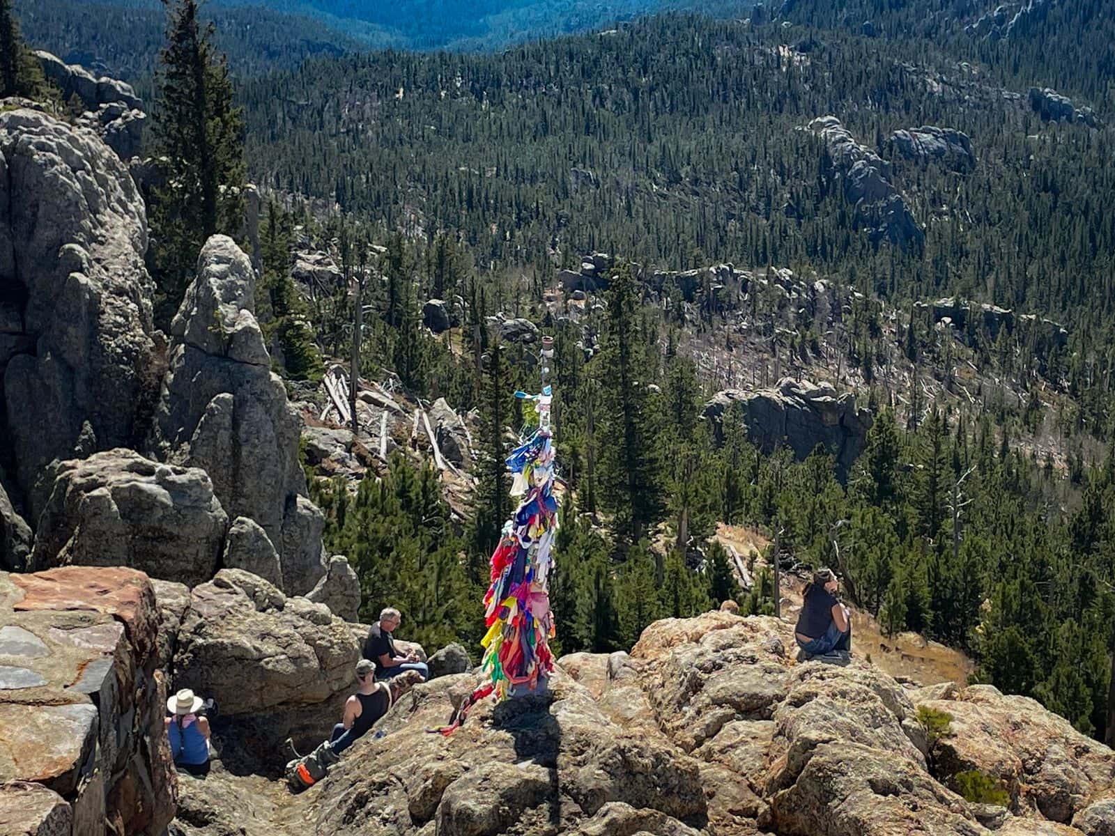 A gathering of federal and tribal officials look out upon South Dakota’s West River wilderness after hiking up Black Elk Peak.