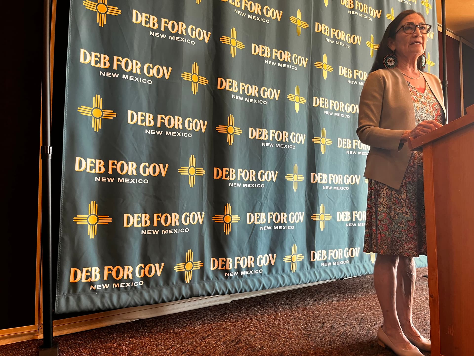 Deb Haaland stands at a podium during a press conference