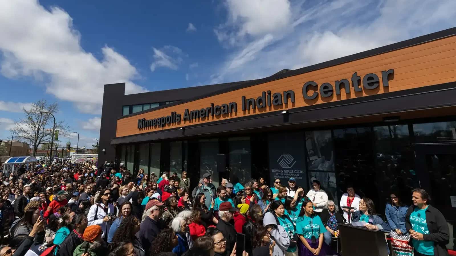 Hundreds of people listen to executive director Mary LaGarde welcome guests to the grand re-opening of the Minneapolis American Indian Center on Wednesday. (Ben Hovland, MPR News)