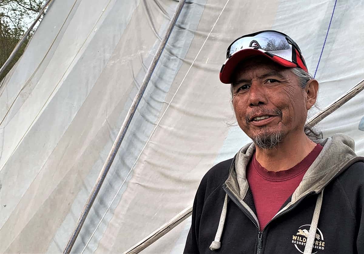 Toby Patrick, who hosted an Easter feast in April of 2020 that violated his tribes' COVID-19 restrictions and led to citations for 17 Indians, a fight against cultural rights, stands next to his family's canvas longhouse at his home on the Umatilla Indian Reservation. PHOTO CREDIT/Underscore.news