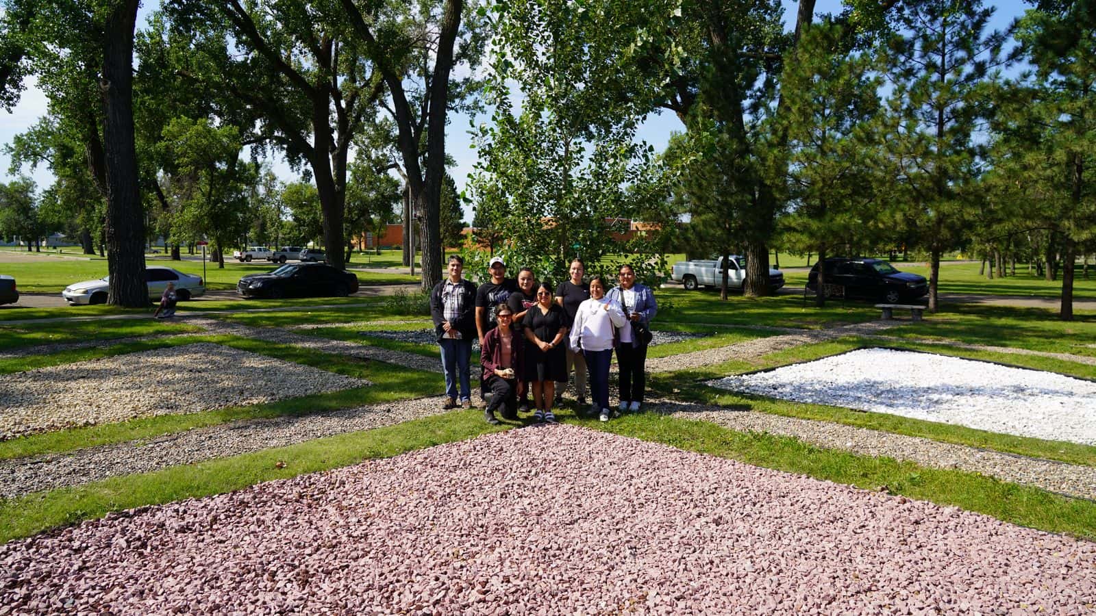 UTTC food sovereignty coordinator Sonia Ciavarelli, middle, stands with fellow faculty and UTTC students in the center of the reconstructed campus medicine wheel, Bismarck, North Dakota, Friday, Aug. 15.