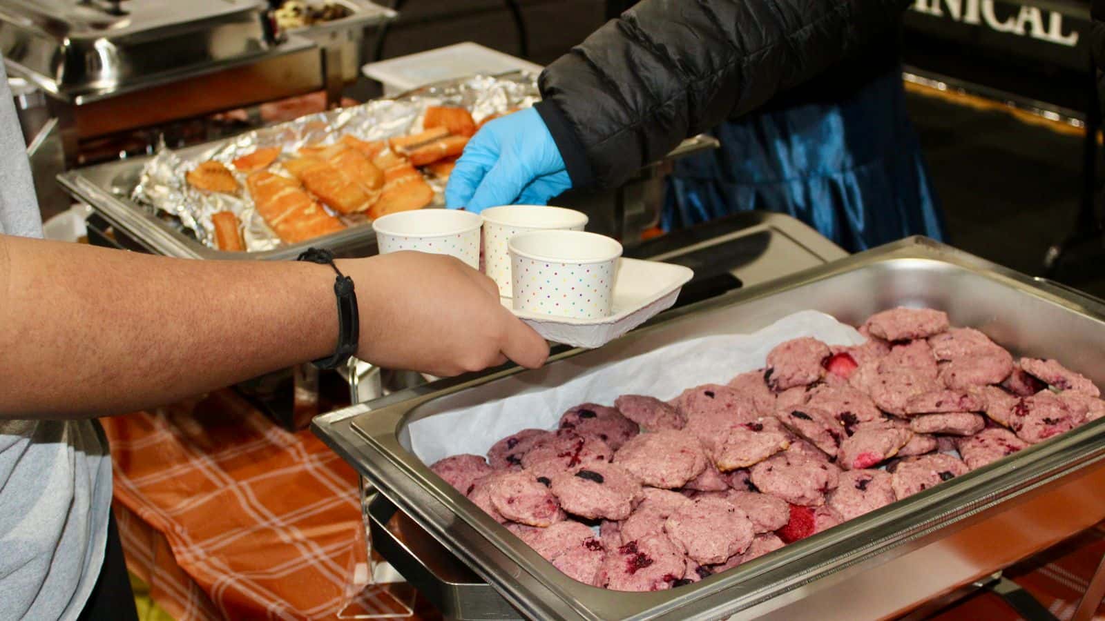 UTTC students from Sisseton-Wahpeton Oyate serve wild berry blue cornmeal cookies, smoked salmon and soup at the “Taste the Earth” event, Bismarck, North Dakota, Tuesday, Nov. 25, 2025.