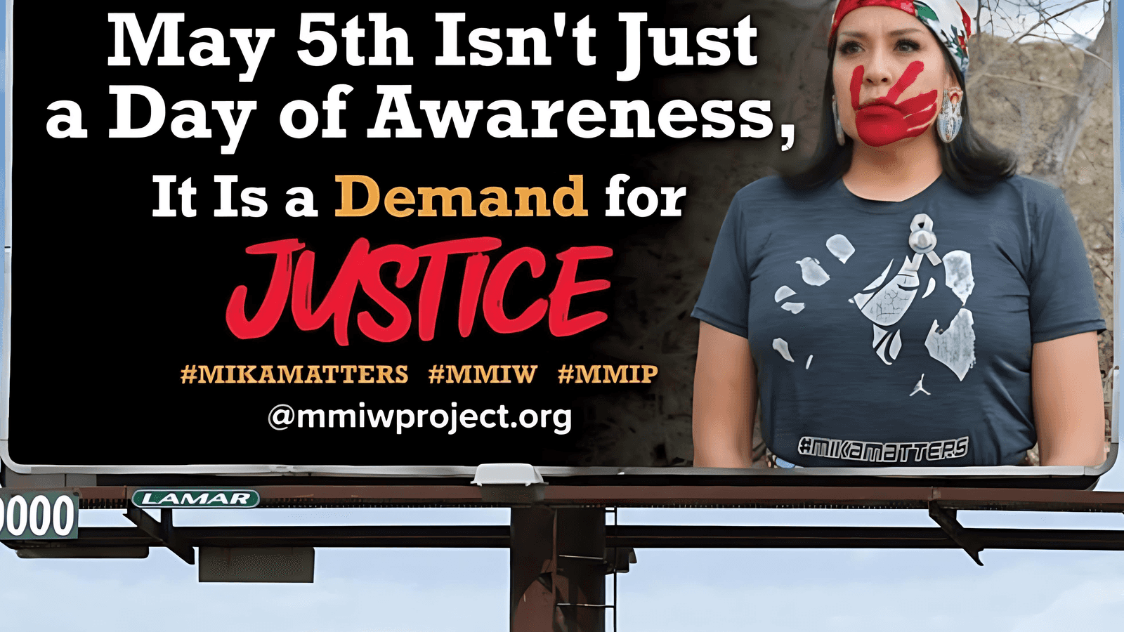 Billboard showing Mika Westwolf’s mother, Carissa Heavy Runner, wearing a Mika Matters shirt and a red MMIP handprint over her mouth. (Photo credit: Jen Murphy)