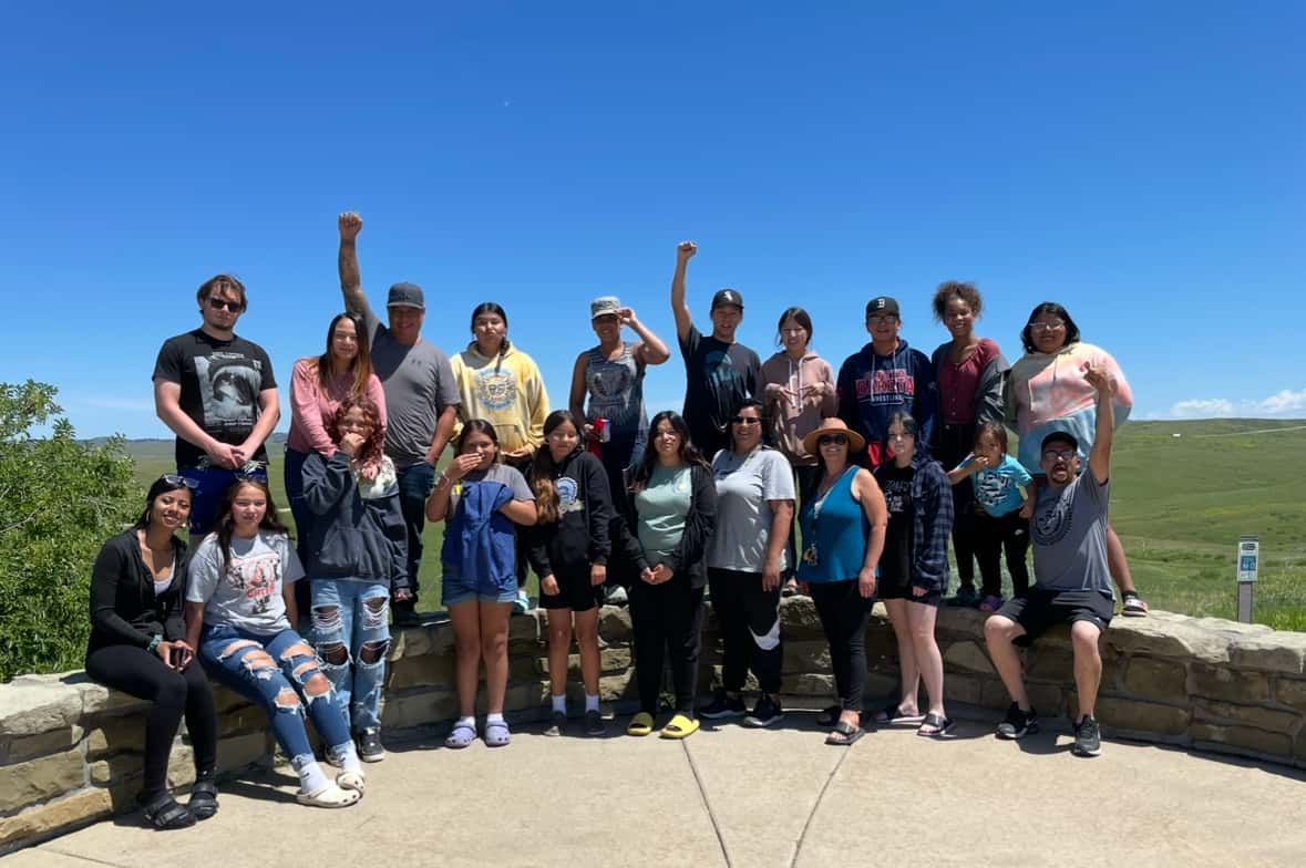 The Defenders of the Water students stand with their instructors, some raising their fists as a symbol of Native solidarity, Little Bighorn Battlefield National Monument, Montana, June 2023.