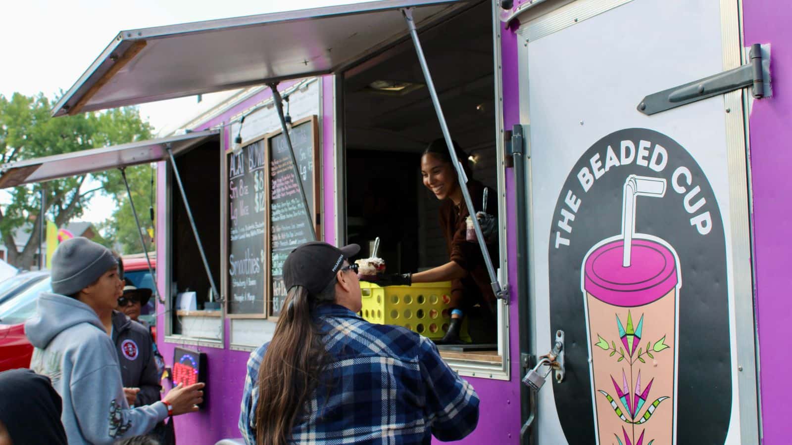 Saydee Archambault, citizen of the Assiniboine Tribe from Fort Belknap, gives a customer an acai bowl, Bismarck, North Dakota, Saturday, Sept. 6, 2025. This was the Beaded Cup’s debut at the UTTC International Powwow. (Buffalo’s Fire Photo/Gabrielle Nelson)