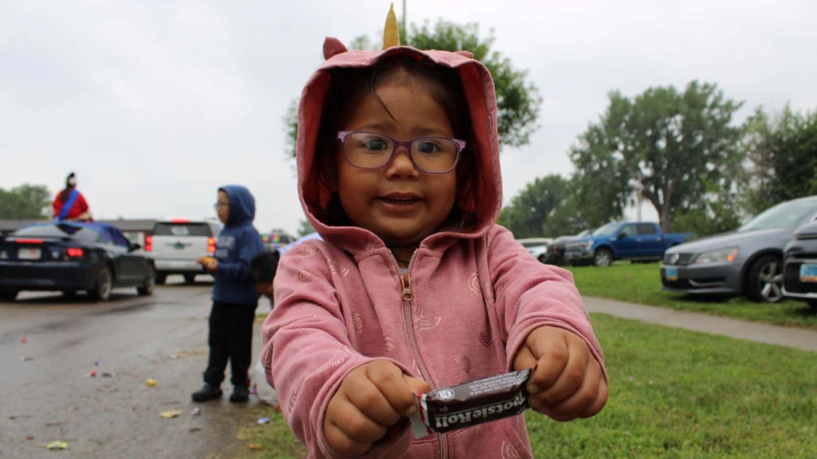 Jaylee Four Swords’s daughter presents her recently retrieved Tootsie Roll at the Long Soldier Parade, Saturday, Aug 2.
