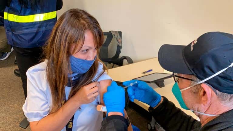 In this Feb. 19, 2021, file photo, Grace John, who works at a school in San Lorenzo, gets a COVID-19 shot at a mobile vaccination clinic run by the Federal Emergency Management Agency and the state in Hayward, California. (AP Photo/Terry Chea, File)