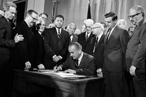President Lyndon B. Johnson signs into law the Fair Housing Act during a ceremony in the East Room of the White House in Washington, D.C., on April 11, 1968. (AP Photo)