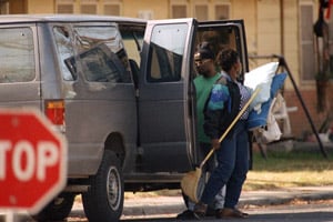 A woman exits a van before she enters a house in Vidor Village in Vidor, Texas, a historic center of Klu Klux Klan activity, on Jan. 13, 1994. HUD Secretary Henry Cisneros called in the U.S. Marshals, the FBI and police to escort four black adults and seven children into the buildings. (Hillary F. Hoffman/AP Photo)