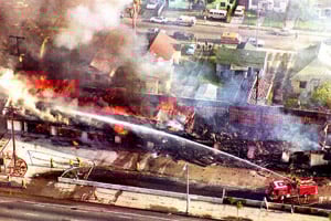 A fire department crew sprays water on a burning mini-mall in south Los Angeles on April 30, 1992 after a night of rioting. The riots took place after a jury acquitted police officers in the beating of Rodney King, a black motorist. (Mike Nelson/AFP/Getty Images)