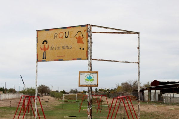 Parque De Los Ninos renovated community gardening. White metal frame with children drawn on a sign. Photo from Borderzine.com