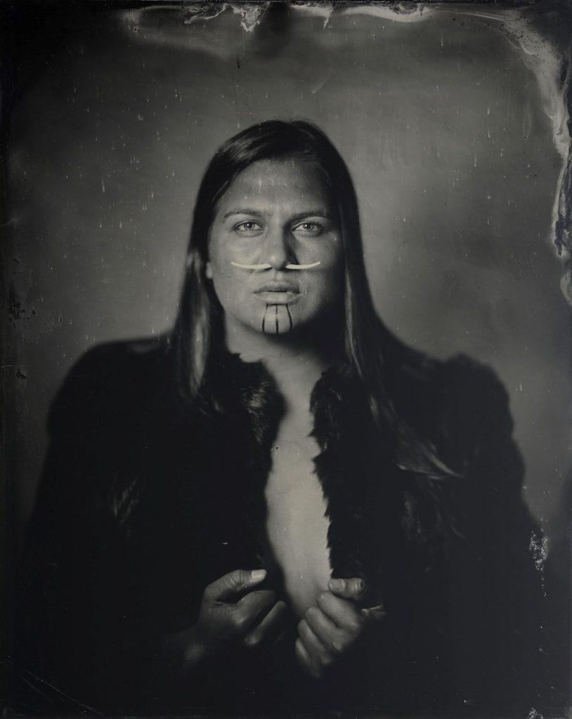 Kali Spitzer sepia traditional portrait first nations indigenous woman wearing fur coat bone through nose long hair