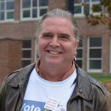 rich holschuh head shot Native American man smiling and wearing a white shirt