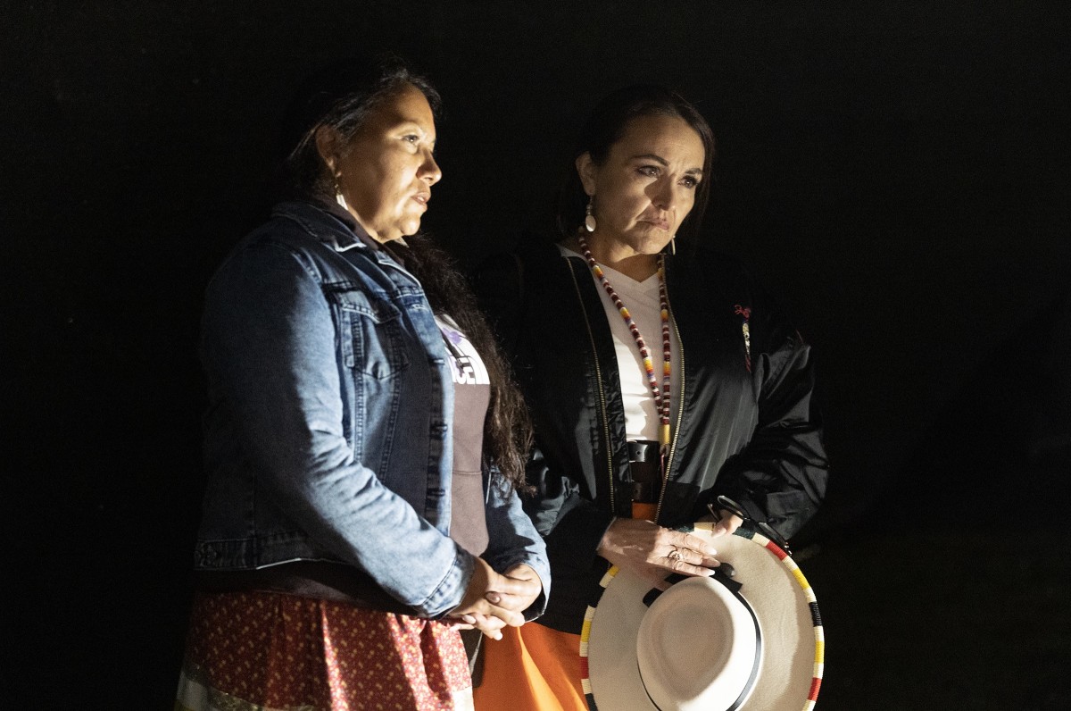 Chairperson Lonna Street, left, Spirit Lake Tribe, and  Tamara St. John, Sisseton Wahpeton Oyate historian and a South Dakota state representative, stand in the Indian Cemetery at the former site of the Carlisle Indian Industrial School late in the evening of Sept. 17, 2023. Work in the cemetery disinterring the graves of Amos LaFromboise and Edward Upright had gone on for approximately 11 hours on a rainy day. (Photo by Charles Fox for ICT)